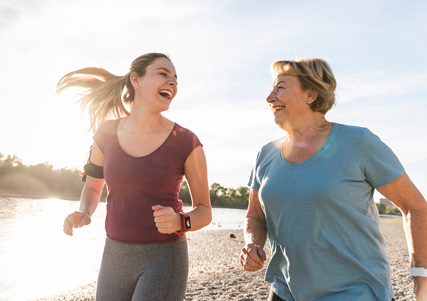 Two women walking on the beach and talking
