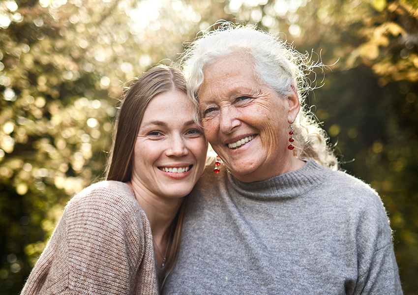 Grandmother and granddaughter smiling at camera